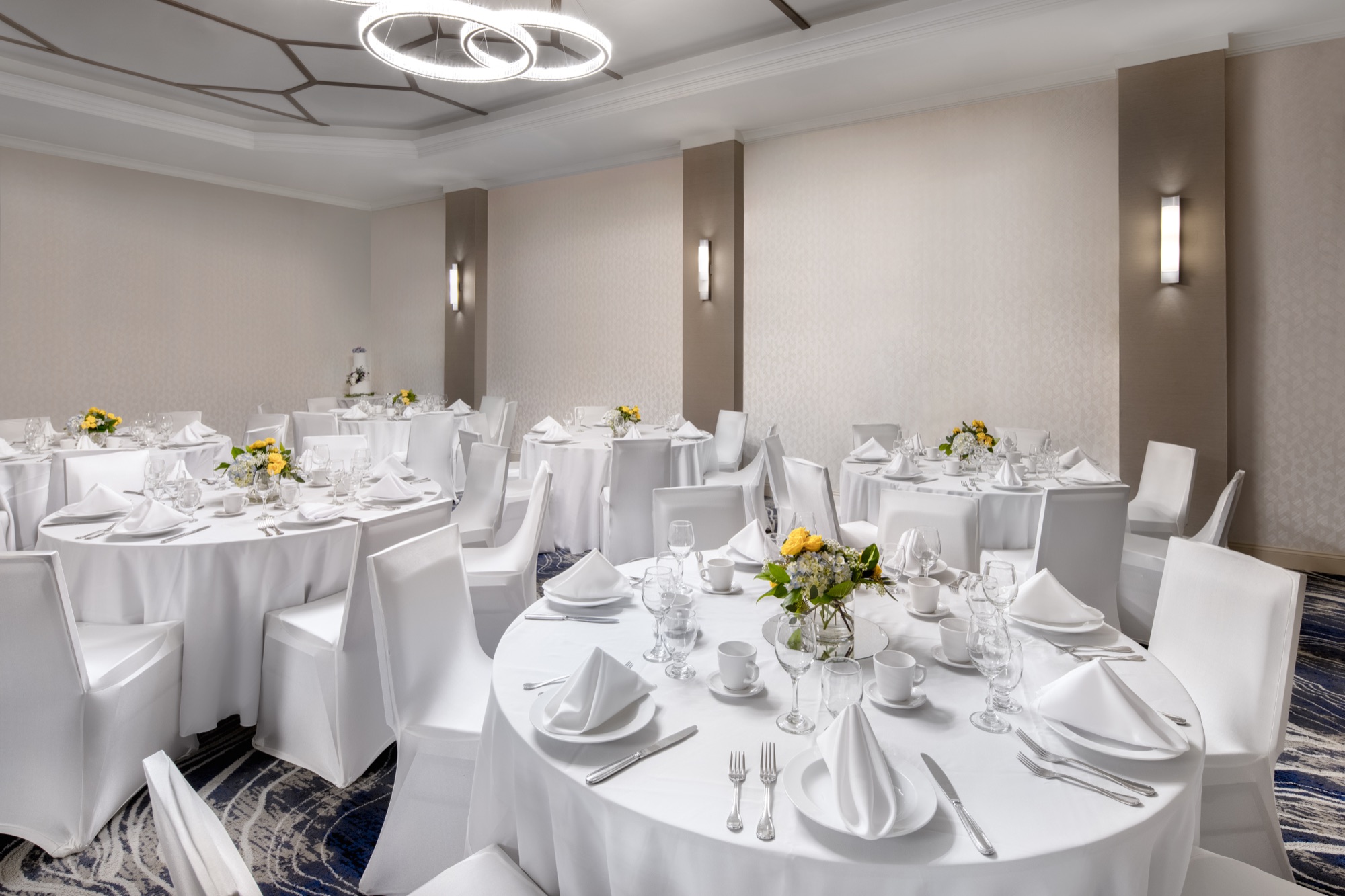 Wedding table settings beneath the ballroom chandeliers