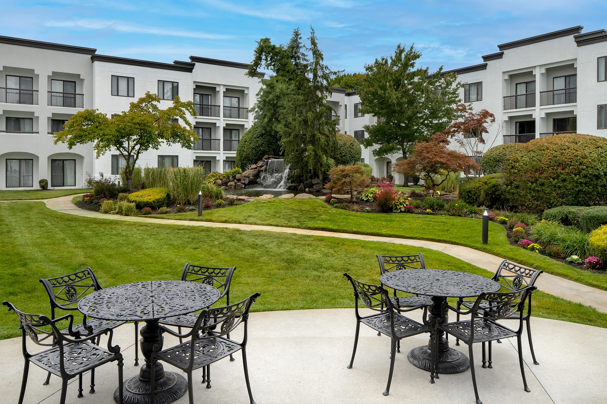 Cafe tables on the courtyard terrace looking across the lawn to the falls